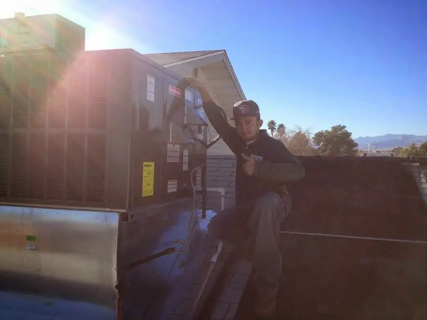 HVAC technician performing Heat Pump Repair on a rooftop unit in Danville